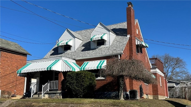 view of front of house with central AC and a front yard