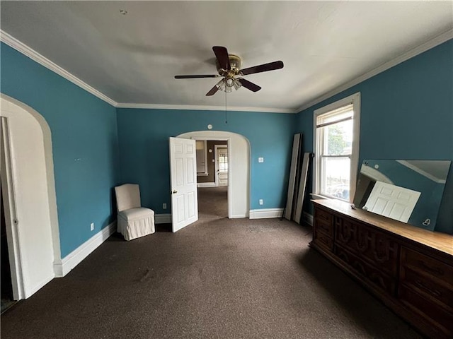 unfurnished bedroom with ceiling fan, ornamental molding, and dark colored carpet