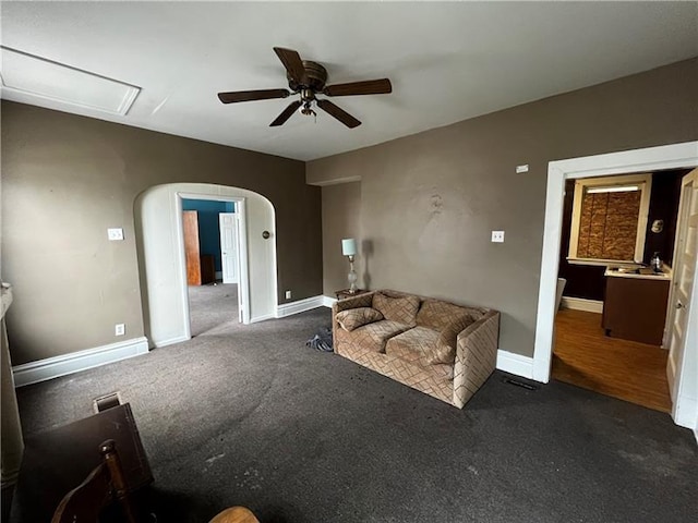 unfurnished living room with ceiling fan and dark carpet