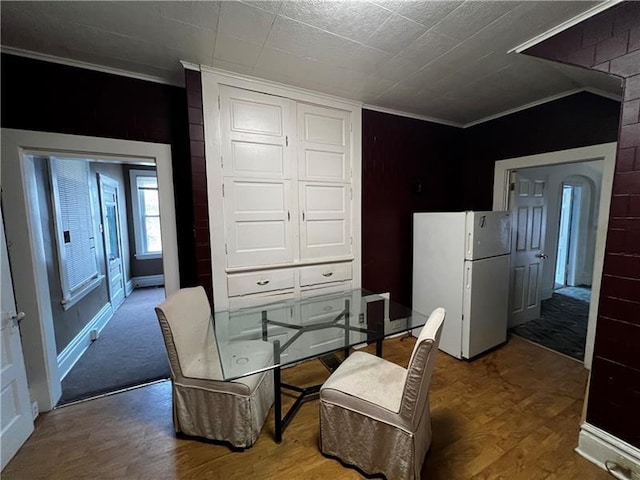 dining space featuring ornamental molding and hardwood / wood-style floors