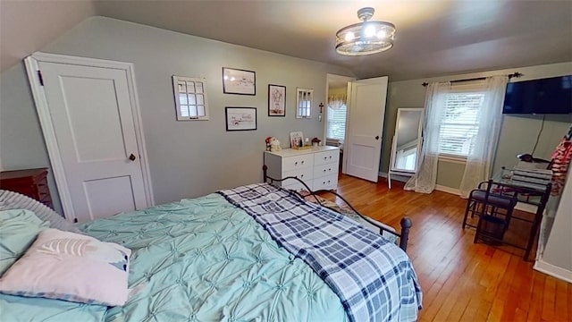 bedroom featuring hardwood / wood-style flooring and vaulted ceiling