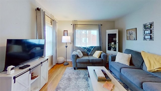 living room featuring a wealth of natural light and light hardwood / wood-style flooring