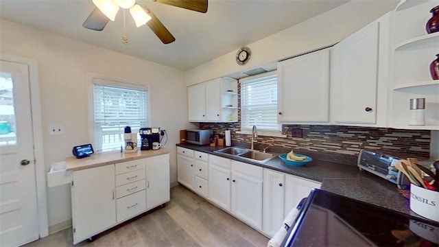 kitchen featuring tasteful backsplash, sink, white cabinets, ceiling fan, and light hardwood / wood-style floors