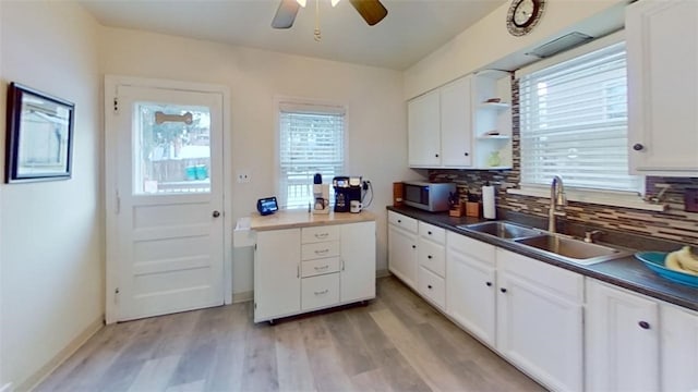 kitchen with sink, white cabinets, and light hardwood / wood-style flooring