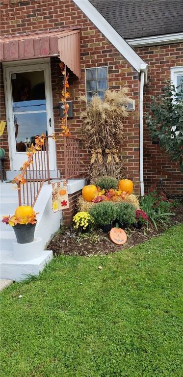 view of exterior entry with a yard