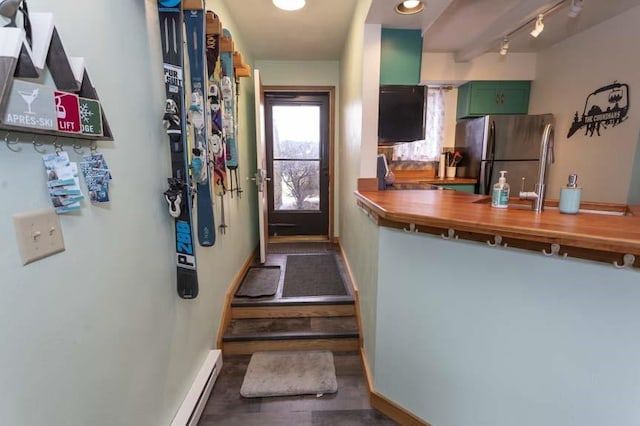 kitchen featuring wooden counters, green cabinets, and stainless steel fridge