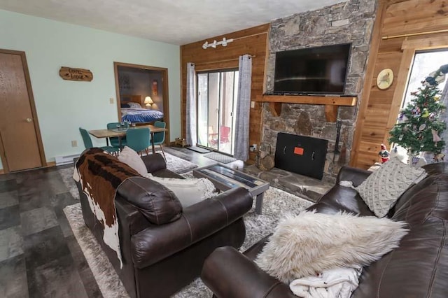 living room featuring plenty of natural light, dark wood-type flooring, a fireplace, and baseboard heating