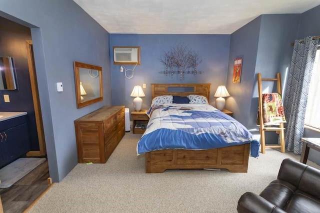 bedroom with a wall mounted AC and light colored carpet