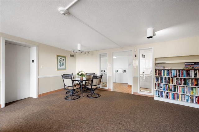 carpeted dining space with a textured ceiling