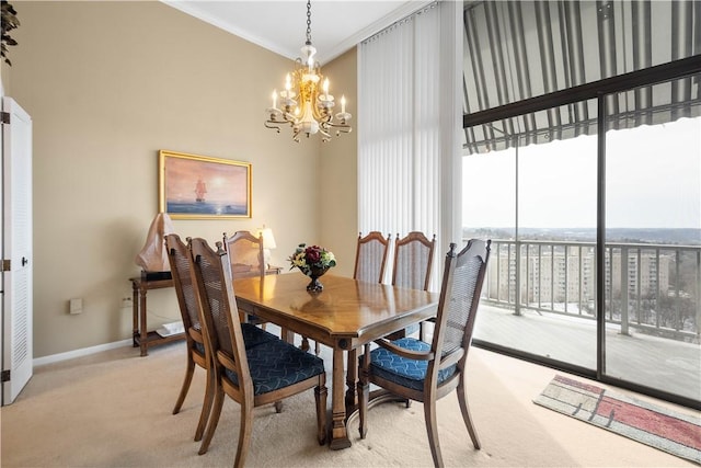 dining area featuring crown molding, light carpet, and an inviting chandelier