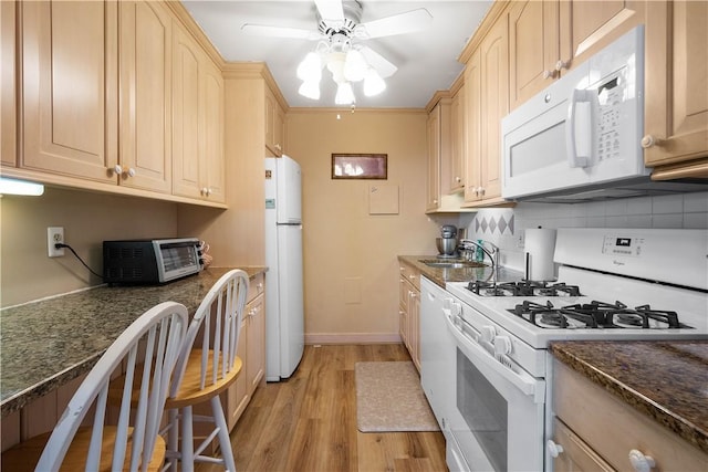 kitchen featuring light brown cabinetry, sink, white appliances, and decorative backsplash