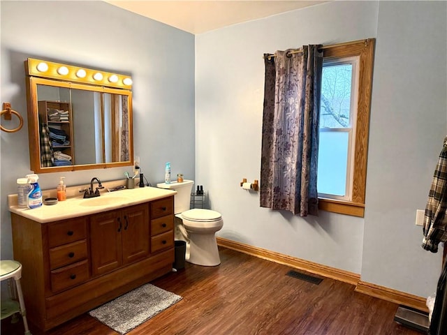 bathroom featuring vanity, wood-type flooring, and toilet