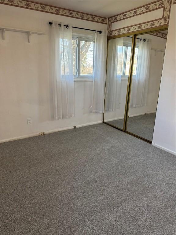 unfurnished bedroom with carpet and a closet