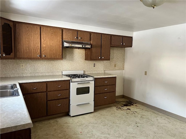 kitchen featuring tasteful backsplash, sink, dark brown cabinetry, and gas range gas stove