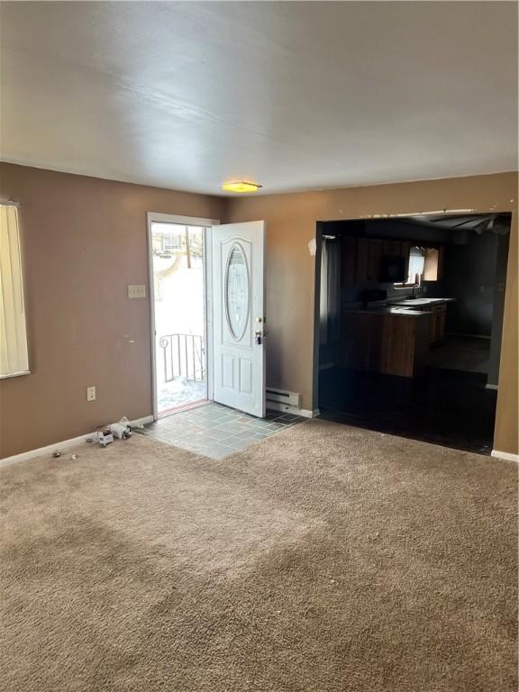 entryway with a baseboard heating unit and carpet