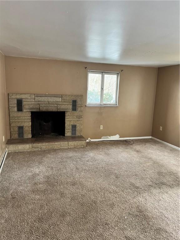 unfurnished living room featuring baseboards, a fireplace, visible vents, and carpet flooring