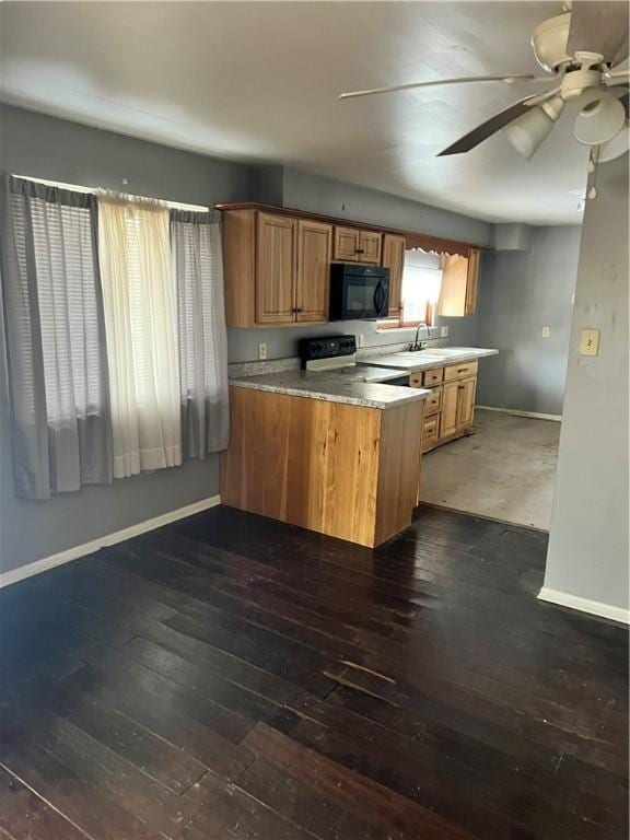 kitchen featuring dark wood-type flooring, sink, electric range, kitchen peninsula, and ceiling fan