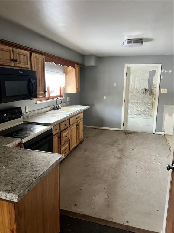 kitchen featuring brown cabinetry, baseboards, a sink, and black appliances