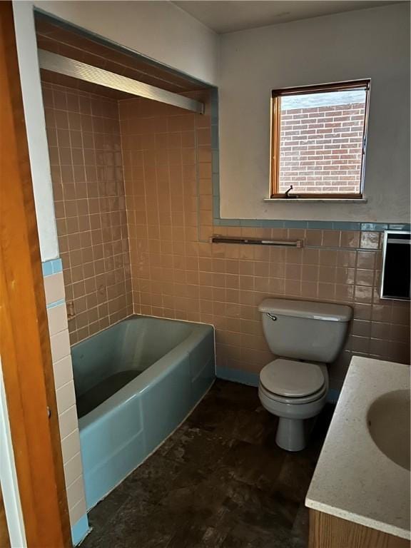 full bathroom featuring vanity, toilet, tiled shower / bath combo, and tile walls