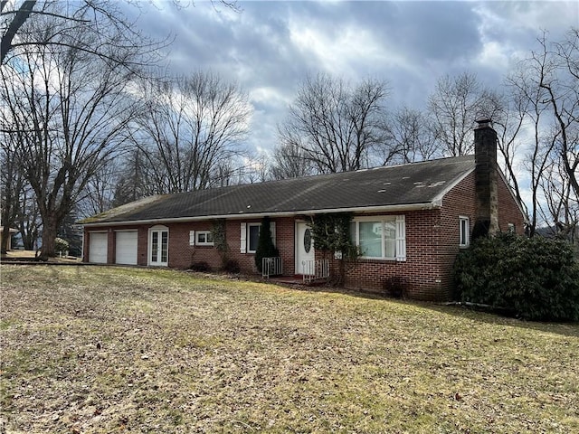 ranch-style house featuring brick siding, a chimney, and an attached garage