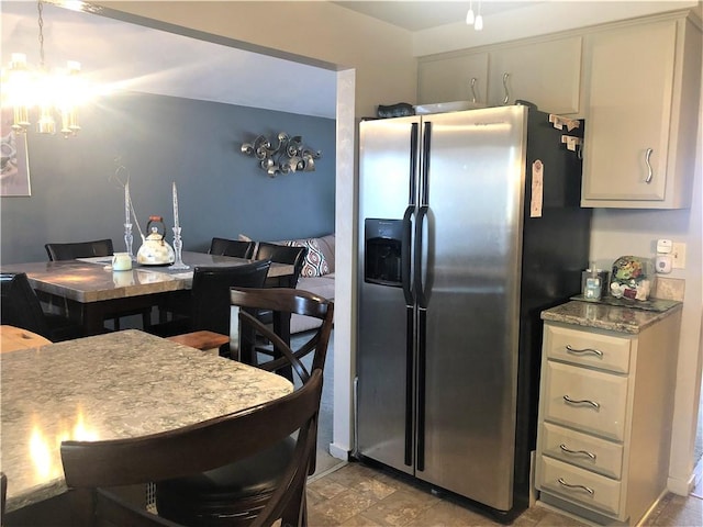 kitchen with stainless steel fridge and a notable chandelier