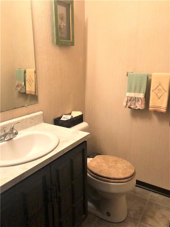 bathroom featuring vanity, tile patterned flooring, and toilet