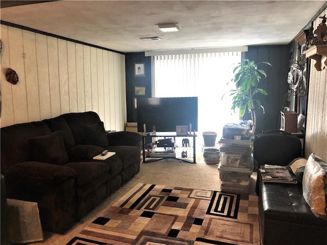 living room featuring carpet and wood walls