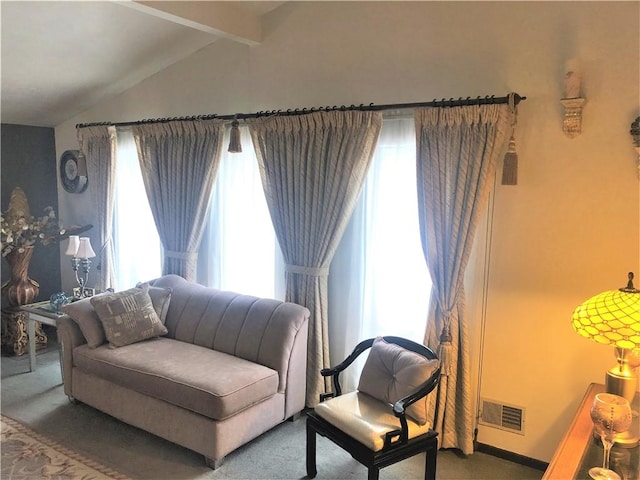 living area featuring carpet and vaulted ceiling with beams