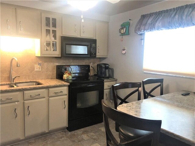 kitchen with sink, backsplash, and black appliances