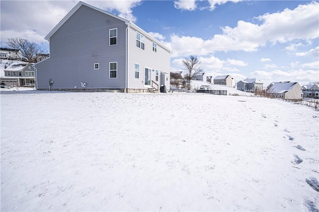 snow covered back of property with entry steps