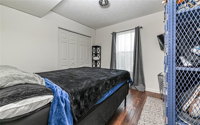 bedroom with pool table, dark hardwood / wood-style flooring, and a closet