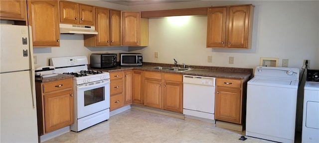 kitchen featuring sink, white appliances, and washing machine and clothes dryer