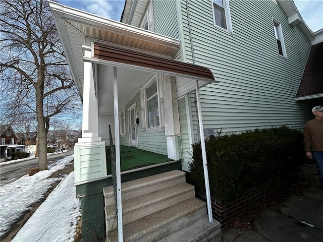 view of snowy exterior featuring a porch