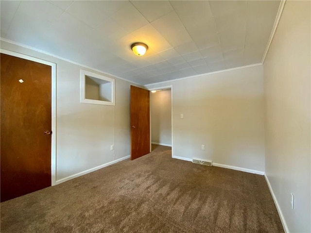 carpeted empty room featuring crown molding