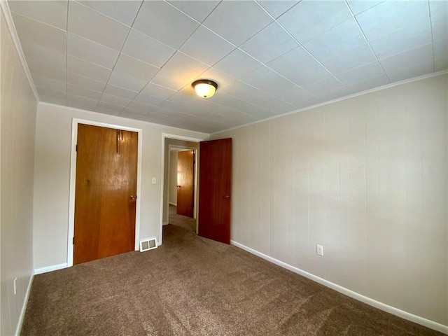 unfurnished bedroom featuring crown molding and carpet floors