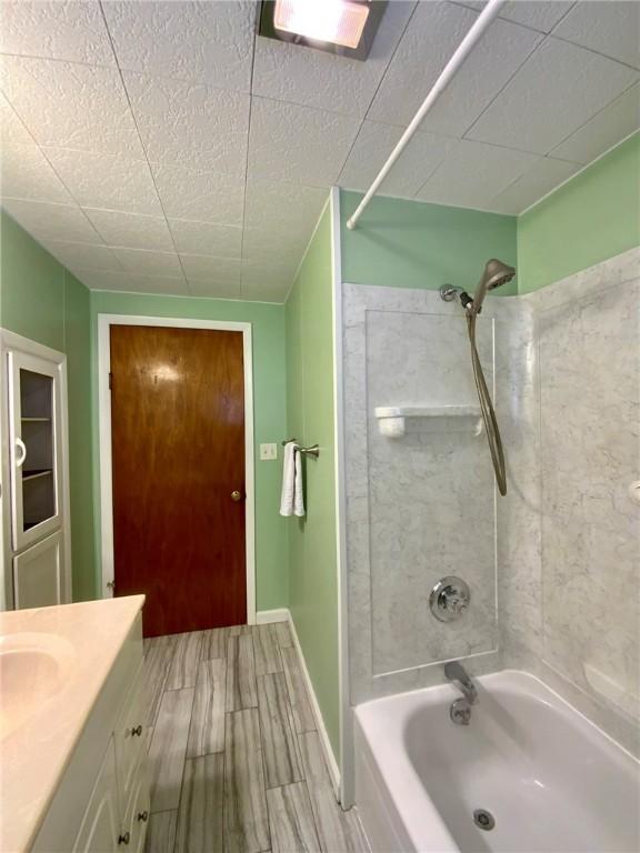 bathroom featuring tiled shower / bath and vanity