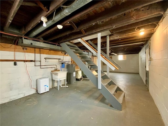 basement featuring electric water heater and sink