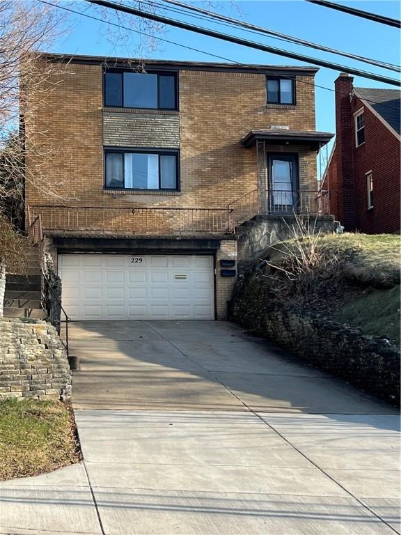 view of front of home featuring brick siding, driveway, and an attached garage