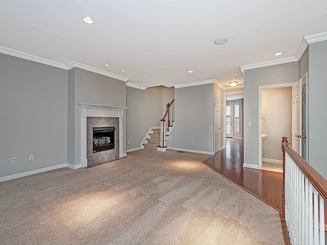 unfurnished living room featuring a fireplace, ornamental molding, and carpet flooring