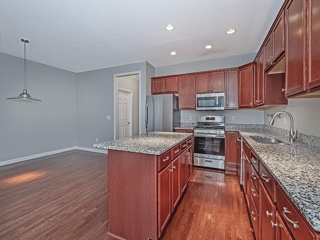 kitchen featuring sink, appliances with stainless steel finishes, dark hardwood / wood-style floors, a kitchen island, and decorative light fixtures