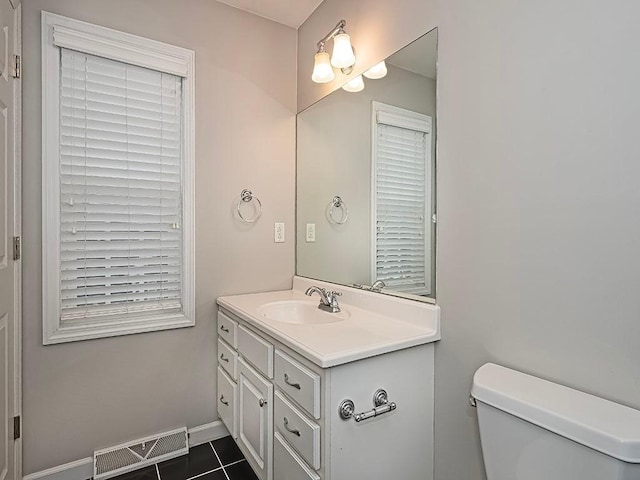 bathroom featuring vanity, tile patterned floors, and toilet