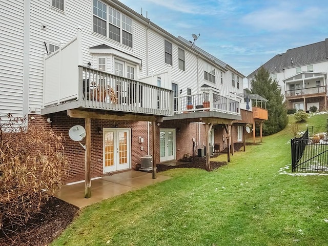 back of property with french doors, a yard, a deck, and a patio area