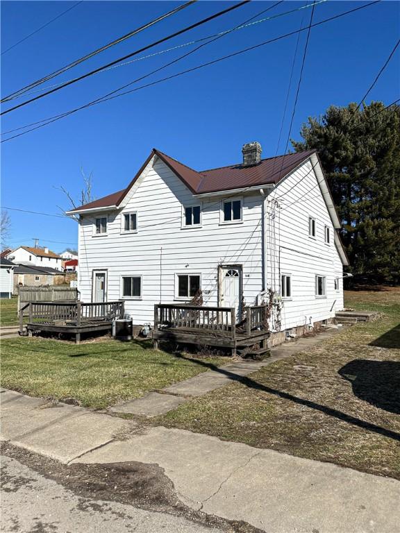 rear view of house with cooling unit, a yard, and a deck