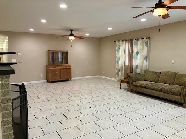 living room with a fireplace and ceiling fan