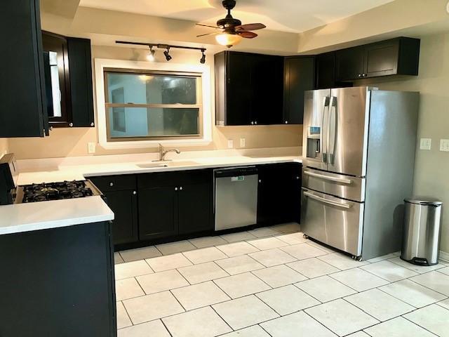 kitchen featuring appliances with stainless steel finishes, sink, light tile patterned floors, and ceiling fan