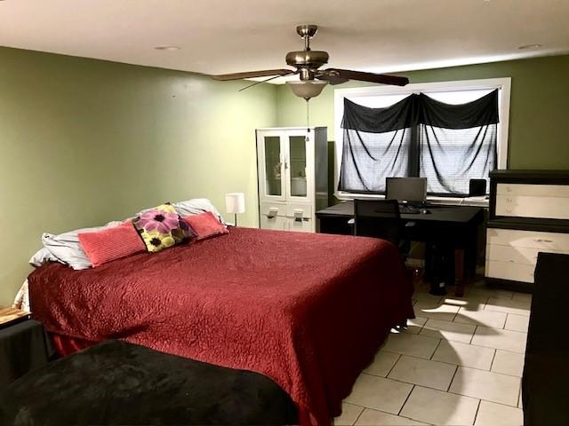 tiled bedroom featuring ceiling fan