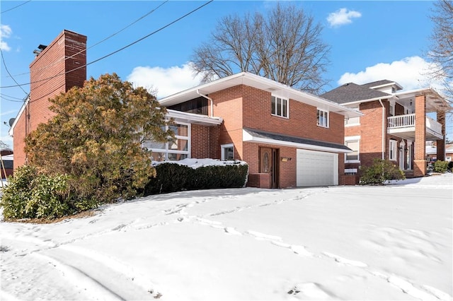 snow covered property featuring a garage