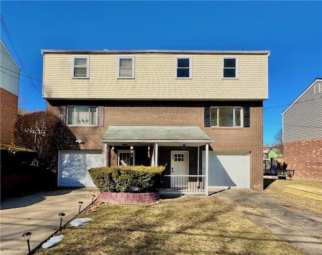 view of property with a porch, a garage, and a front yard