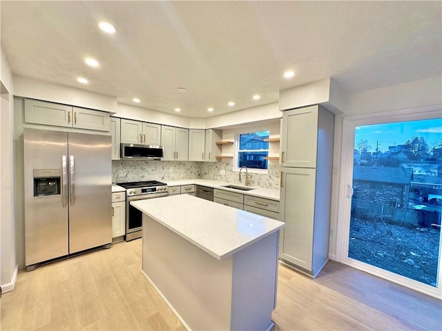 kitchen featuring sink, gray cabinetry, a center island, light hardwood / wood-style flooring, and stainless steel appliances