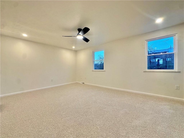 carpeted spare room featuring ceiling fan